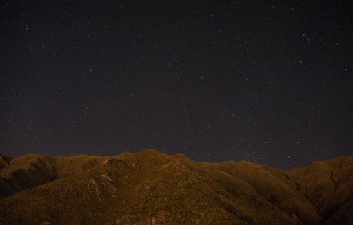 A closeup shot of a brown hill under the starry sky
