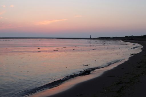 A wide shot of a beach ridge under the beautiful colorful sky during sunset
