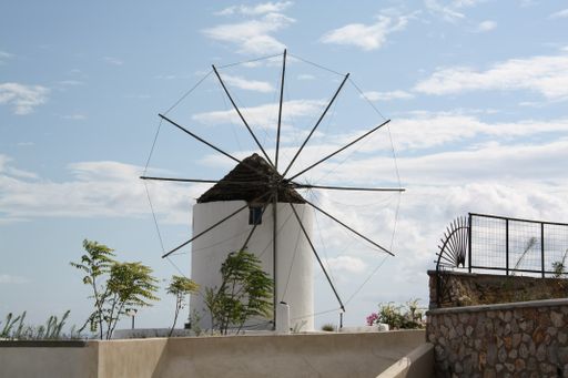 A windmill surrounded by greenery under the sunlight in Santorini, Greece