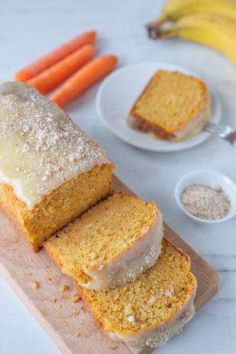 A vertical shot of a carrot banana bread in slices on a wooden board for Easter
