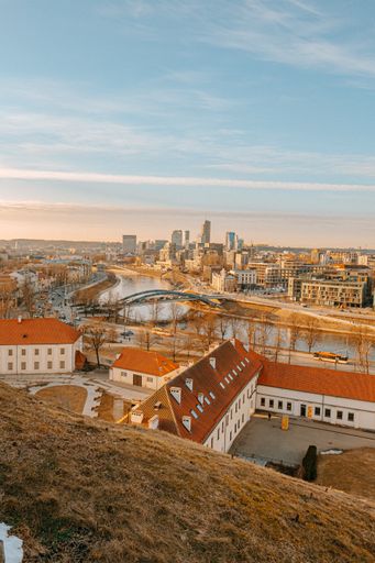 A vertical high angle shot of a Vilnius city red roof buildings and a  Mindaugas Bridge on the river