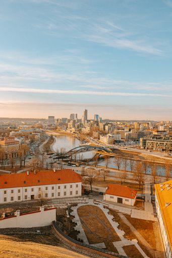 A vertical high angle shot of a Vilnius city red roof buildings and a  Mindaugas Bridge over the river