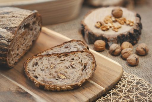 A closeup shot of slices of walnut wheat bread on a wooden chopping board