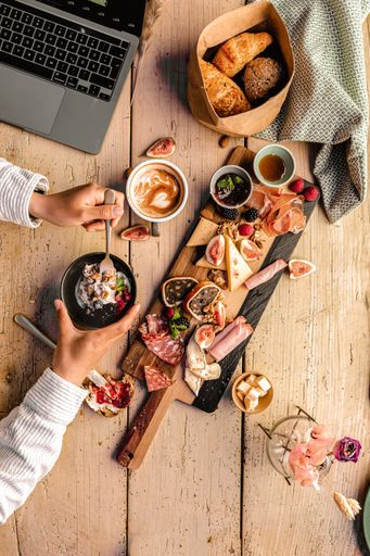 A vertical closeup of the wooden table with various types of food.