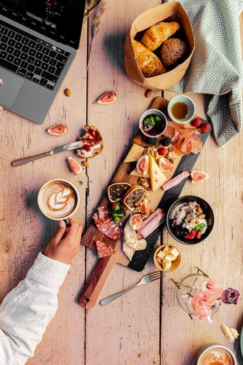A vertical closeup of the wooden table with various types of food.