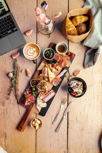 A vertical closeup of the wooden table with various types of food.