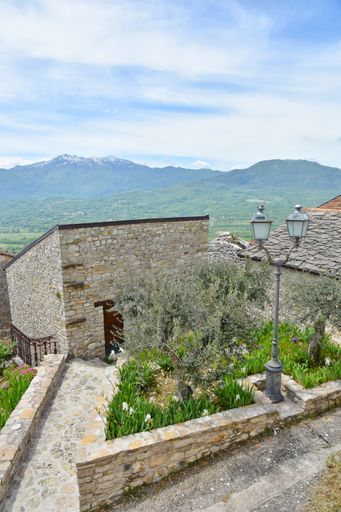A beautiful view of a stone street in Macchiagodena village in the Molise region of Italy by mountains and blue sky