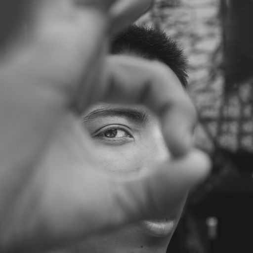 A selective focus shot of a portrait of a male showing ok sign