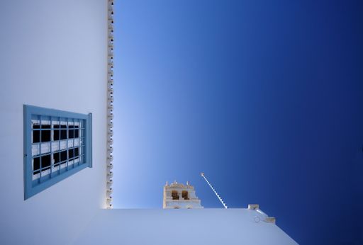 a low angle shot of a white building in Spetses island of Greece.