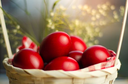 A closeup shot of Easter red eggs in wicker basket in blurred background