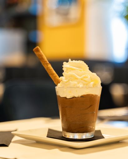 A vertical shot of a chocolate drink with whipping cream