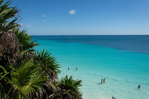 Several people swimming in turquoise Caribbean ocean in Quintana Roo, Mexico Yucatan peninsula