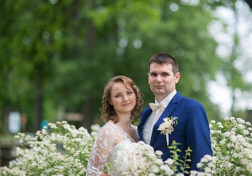 A Caucasian young groom and bride in a wedding day in a park