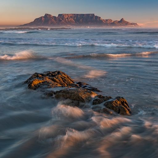 A scenic view of a vast, blue ocean on a bright sunset sky background