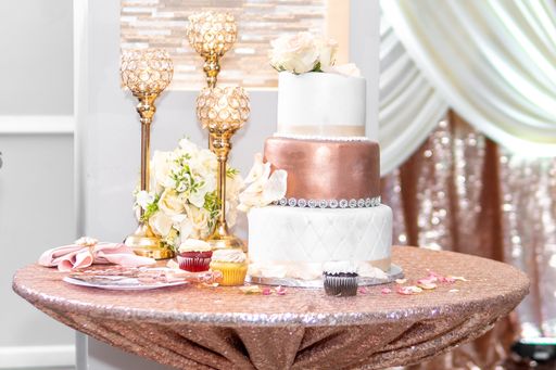 A beautiful wedding reception with pink wedding cake, candlesticks and flowers on the table
