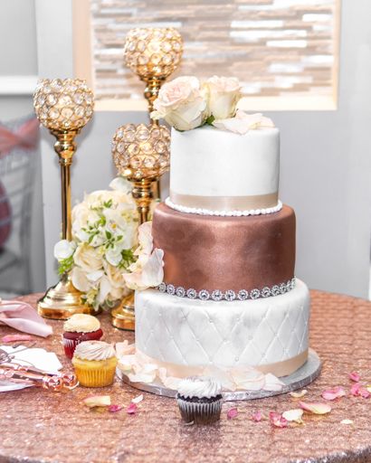A beautiful wedding reception with pink wedding cake, candlesticks and flowers on the table
