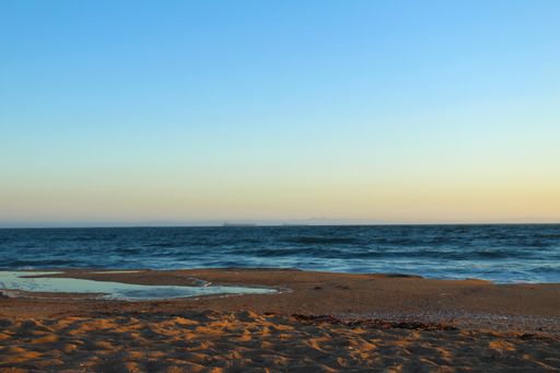 A beautiful view of a beach and the Pacific ocean at sunset in California