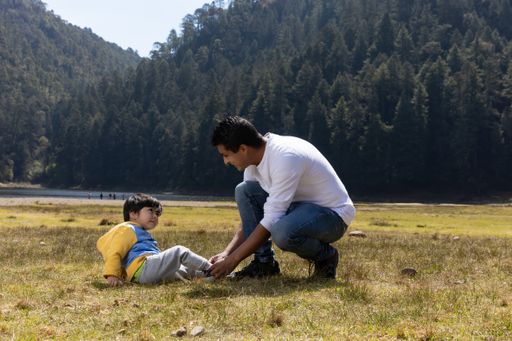 A Mexican father and his son having fun outdoors in a park