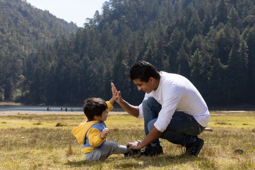 A Spanish father and his son playing outdoors in a park