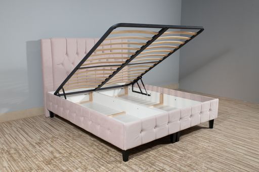 A pink bed with a storage space revealed by lifting the wooden slatted base
