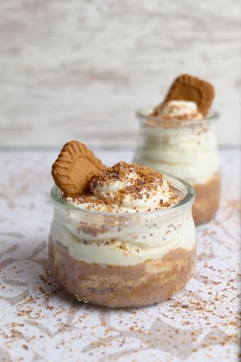 A vertical shot of a coffee made with cream, sugar, and cacao on a blurred background