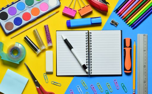 An open notebook with a pen and stationery on a yellow-blue background
