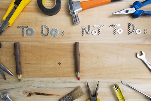 A high angle shot of the phrases "to do" and "not to do" made of screws on a wooden surface for planning the work