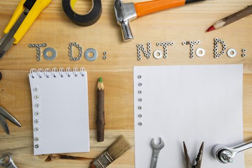 A high angle shot of the phrases "to do" and "not to do" made of screws on a wooden surface for planning the work