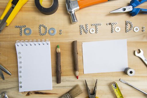 A high angle shot of the phrases "to do" and "not to do" made of screws on a wooden surface for planning the work