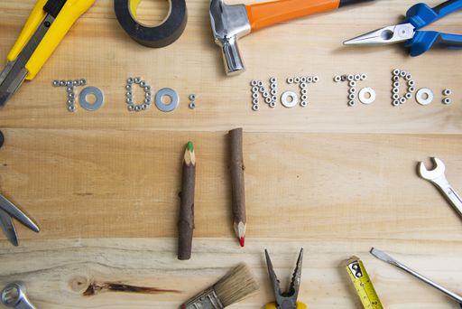 A high angle shot of the phrases "to do" and "not to do" made of screws on a wooden surface for planning the work