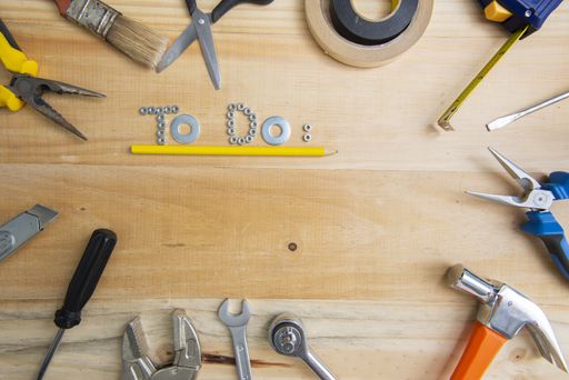 A high angle shot of the phrase "to do" made of screws underlined by a yellow pencil on a wooden surface for planning the work