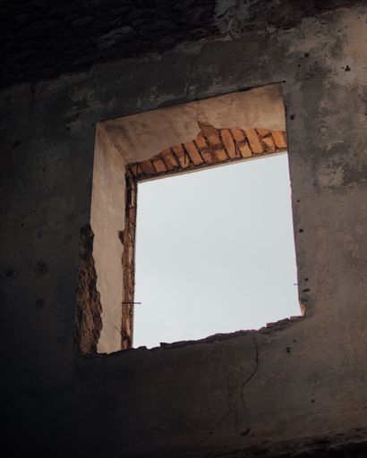 The white sky as seen through an open window of an abnadoned building