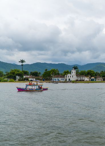A vertical shot of boats and a view of the Samba da Bencao church in Paraty, Brazil