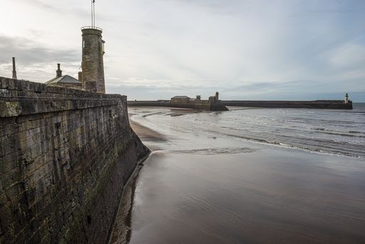 A beautiful view of the old lighthouse in Whitehaven harbor under cloudy sky, Cumbria, UK