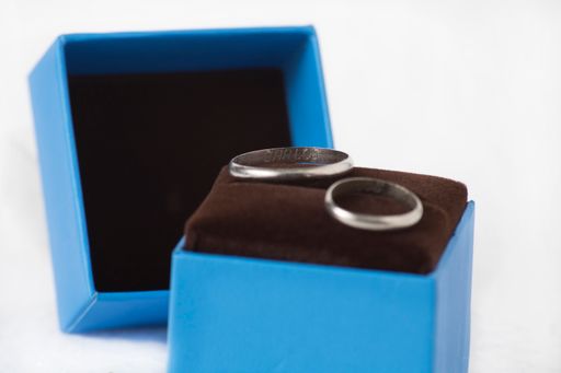 A closeup shot of a couple of wedding rings in blue jewelry box isolated on a white background