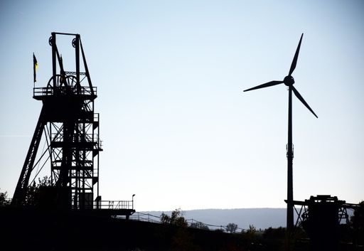 A silhouette shot of wind power plant against a bright clear sky