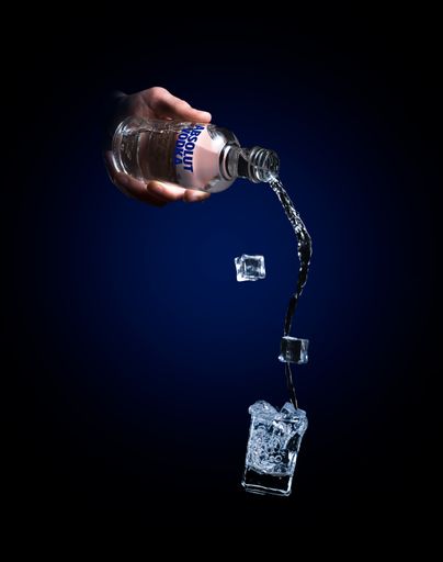 A barman pouring Absolut Vodka from the bottle into a shot glass
