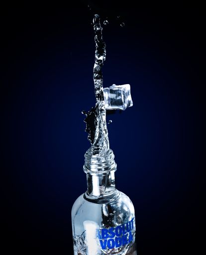 A vertical shot of fresh Absolut Vodka with an ice cube