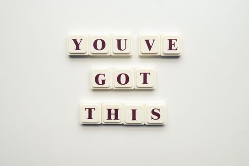 A closeup of scrabble tiles with letters spelling the message "You've Got This" on a white background