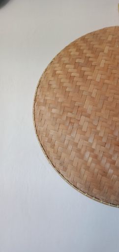 A vertical closeup shot of a mat made of straw on a white surface