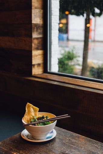 Thai victory noodles in bowl with chopsticks on restaurant table by window during the day