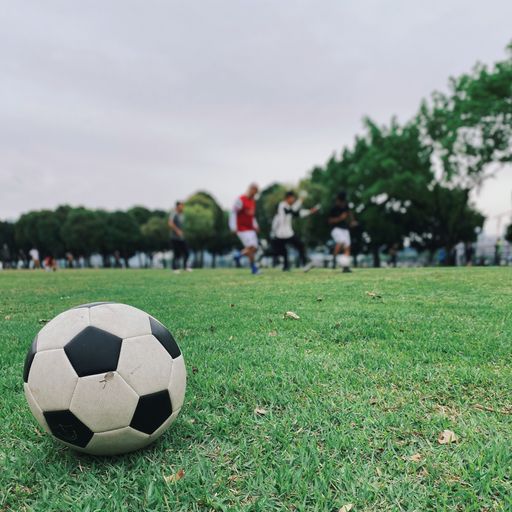 A selective focus shot of a soccer ball in a football field