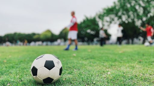 A selective focus shot of a soccer ball in a football field