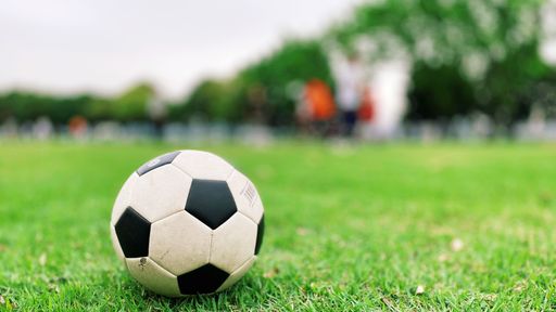 A selective focus shot of a soccer ball in a football field
