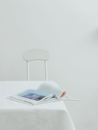 An aesthetic view of an open journal on a table with white tablecloth