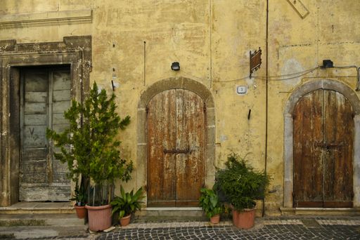 The arched wooden doors on an old house facade in Fiuggi, Lazio, Italy