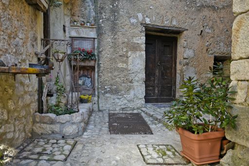 A historic stone house with potted plants in Fumone, Lazio, Italy
