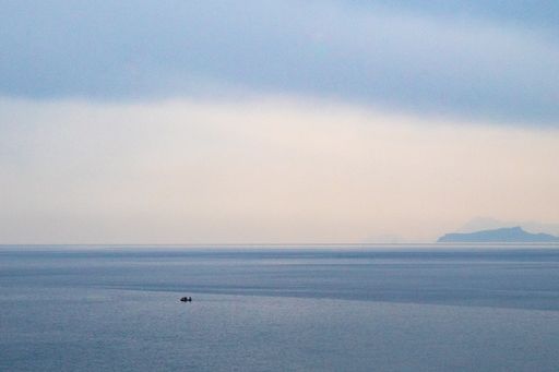A single boat far away in the sea water