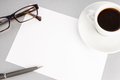 Blank Sheet of paper, eyeglasses and coffee cup on office desk. Template. mock up. Top view