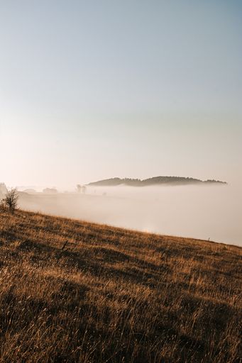 A vertical shot of floating clouds over rural cliffs